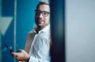 junger Mann mit Brille und Smartphone