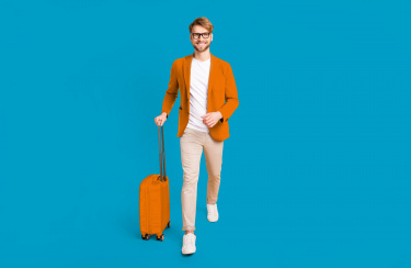 Fröhlicher junger Mann mit Trolley