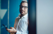 junger Mann mit Brille und Smartphone
