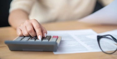 Frau tippt auf einem Taschenrechner