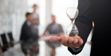 Mann im Büro mit Sanduhr 