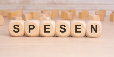 Holzbuchstaben die das Wort Spesen bilden
