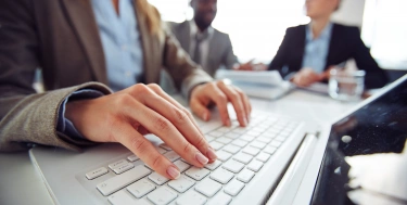 Frau tippt auf einem Laptop