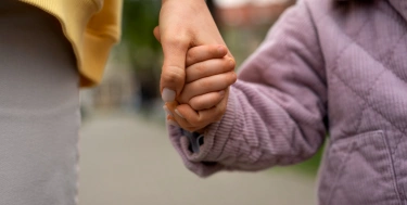 Mutter hält Kind an der Hand