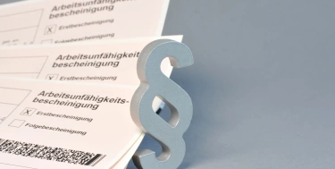 Arbeitsunfähigkeitsbescheinigung + Paragrafenzeichen