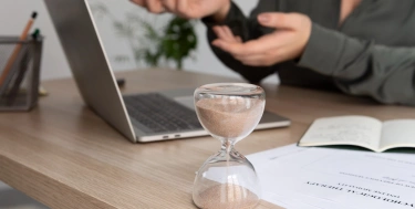frau arbeitet am Schreibtisch mit Laptop und Unterlagen 