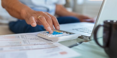 Mann tippt auf einem Laptop