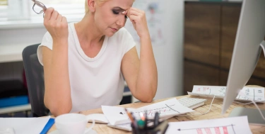 Eine Frau arbeitet am Computer mit einem gestressten Blick