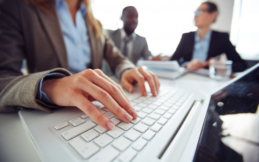 Frau tippt auf einem Laptop