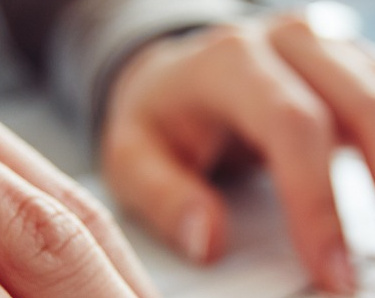 Frau tippt auf einem Laptop