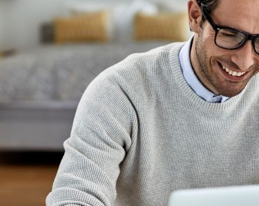 Zufriedener Freelancer arbeitet von zu Hause aus am Computer