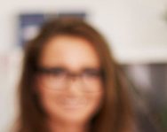 3 Personen sitzen im Büro am Schreibtisch fröhlich lächelnd